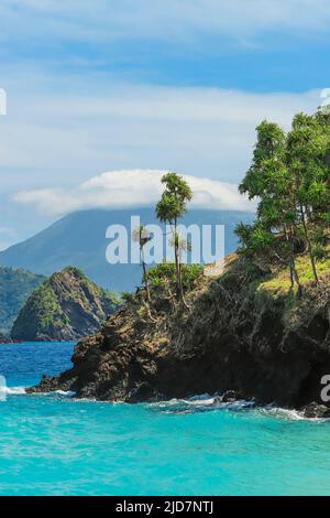 Beautiful turquoise sea at Mahoro Island with cloudy Karangetang volcano beyond. Mahoro, Siau Island, Sangihe Archipelago, North Sulawesi, Indonesia Stock Photo