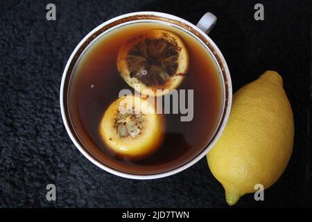white porcelain cup with black hot coffee with slice of  lemon Stock Photo