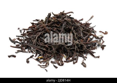 Heap of dried Ceylon blend tea leaves close up isolated on white background Stock Photo