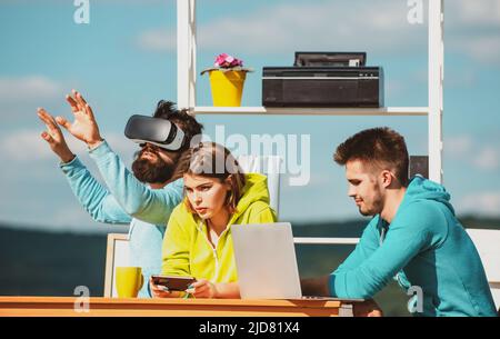 Business people working with virtual reality glasses during a business meeting. Developers in virtual reality simulator in creative office. Stock Photo