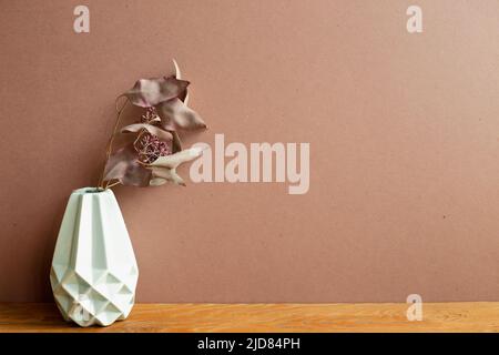 Vase of dry flowers on wooden table. brown wall background. home interior Stock Photo