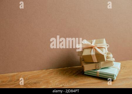 Stack of gift boxes on wooden table. brown wall background Stock Photo