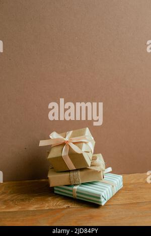 Stack of gift boxes on wooden table. brown wall background Stock Photo