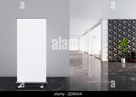 Blank white poster in front of grey wall on marble floor in spacious office area with green plant in a pot near decorative wall and glass wall parlors Stock Photo
