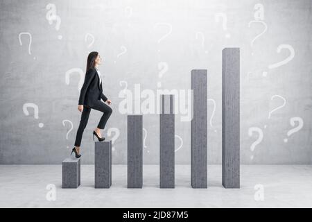 How to succeed and career ladder concept with businesswoman walks up the growing columns on grey wall with question marks background, monochrome Stock Photo