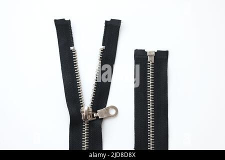 Open metal zippers for clothing on white background Stock Photo