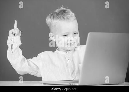 Amazed child using gadgets to study. Computer education for kids. Genius child programming, computer training. Stock Photo