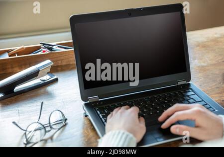 Blank screen laptop computer, home office work. Man type, open notebook on desk, black empty display, copy space Stock Photo