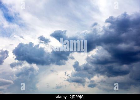Heavy dark cloud on blue sky background, Fluffy cumulus clouds, cloudscape white and grey color,  gloomy weather Stock Photo