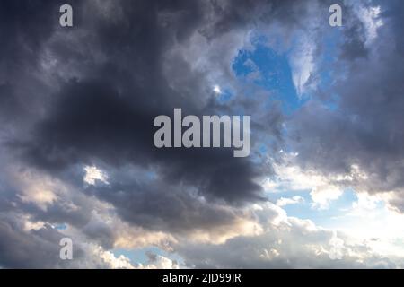 Cumulus cloudscape white grey color and orange shade. Sunrise colorful cloud on blue sky background. Sunset light color the cloudy sky. Twilight, dawn Stock Photo