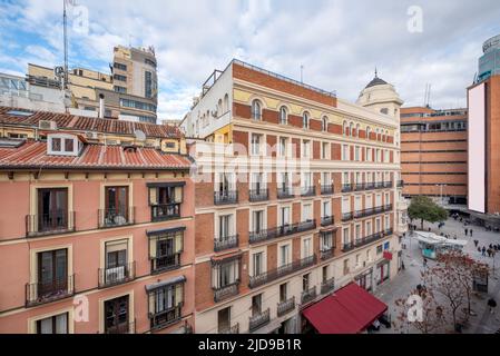 Facades of old urban residential buildings with clay roofs and small attic windows near Plaza del Callao in Madrid Stock Photo