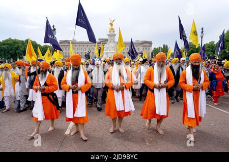 Sikh men hold their swords as they march along The Mall to Trafalgar Square, London, to take part in a rally marking the 38th anniversary of the 1984 Amritsar massacre. Picture date: Sunday June 19, 2022. Stock Photo