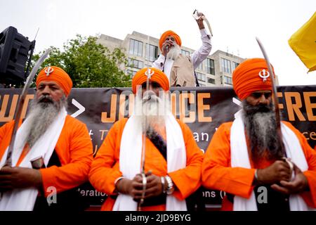 Sikh men hold their swords as they wait to march to Trafalgar Square, London to take part in a rally marking the 38th anniversary of the 1984 Amritsar massacre. Picture date: Sunday June 19, 2022. Stock Photo