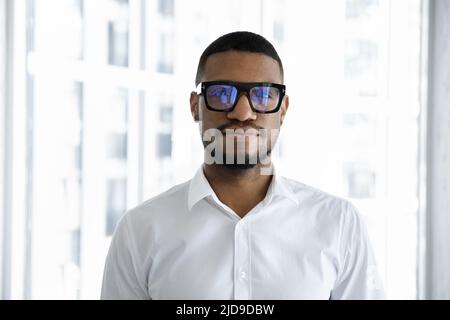 Serious African businessman in white shirt looking at camera Stock Photo
