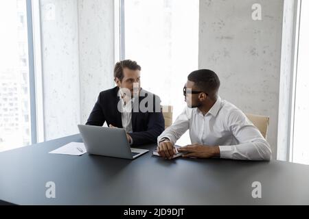 Multi ethnic business partners working on collaborative project at workplace Stock Photo