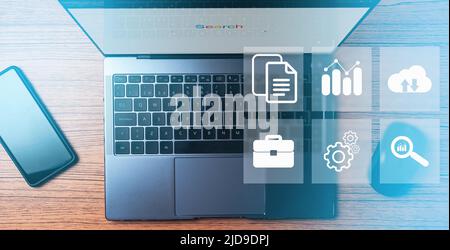 Desk top view with laptop, smartphone and mouse with digital administration interface. Document Management System Concept. Corporate business. Stock Photo