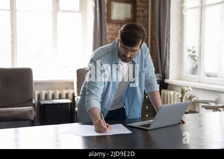 Businessman writes notes on paper, prepare application form, do paperwork Stock Photo