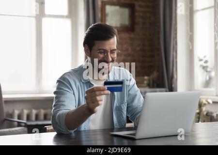Man using credit card and laptop buying on internet Stock Photo