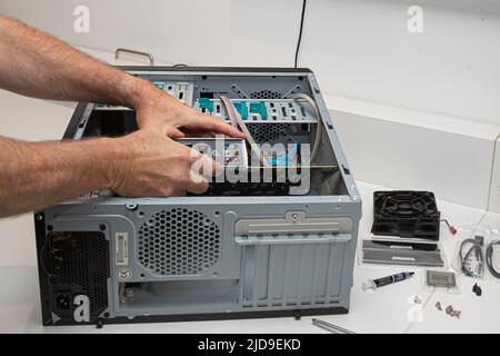 A system administrator installs a motherboard in a computer case Stock Photo