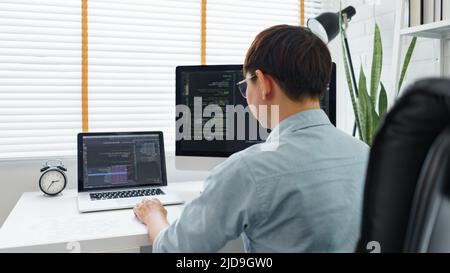 Software development concept, Male programmer typing data code on laptop to develop app and website. Stock Photo
