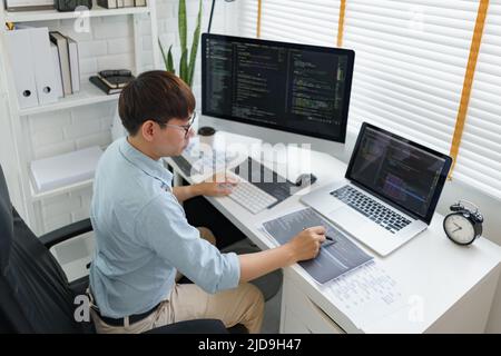 Software development concept, Male programmer pointing on data code to checking website programming. Stock Photo
