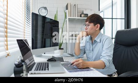 Software development concept, Male programmer read data code to thinking about developing website. Stock Photo