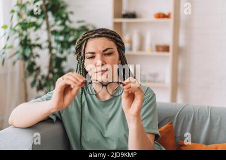 The girl looks at the glasses checking for dirt Stock Photo