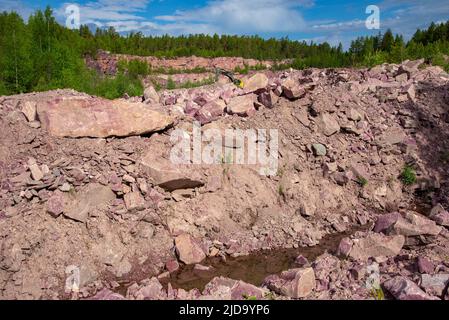 An abandoned quarry for the extraction of raspberry quartzite. Shoksha, Karelia. Russia Stock Photo