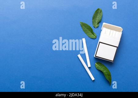 Pack of menthol cigarettes and fresh mint on colored table, Menthol cigarettes top view flat lay. Stock Photo