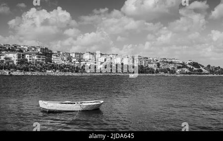 White wooden boat is anchored in Avcilar district of Istanbul city, Turkey. Black and white photo Stock Photo