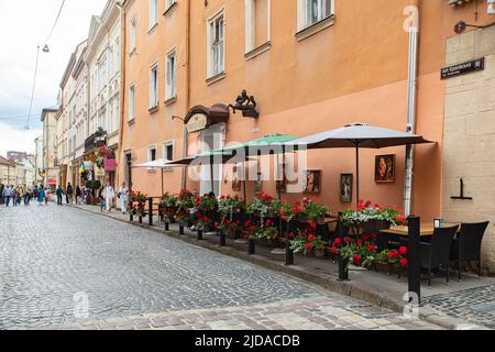 Lviv, Ukraine - June 1, 2022: Outdoor cafe in Lviv, Ulraine. Centaur sculpture on building Stock Photo