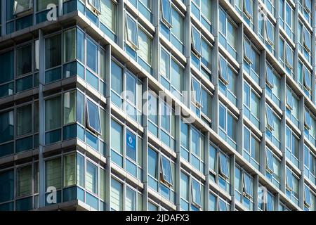 Apartment block or flats in Liverpool, England, UK. Repetition of parallel lines perspective corrected. A Chelsea FC flag hangs in a window Stock Photo