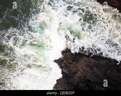 View from above. Raging ocean. Storm. White foamy waves break on the rocky shore. The beauty and majesty of nature. There is no one in the photo. Ecol Stock Photo