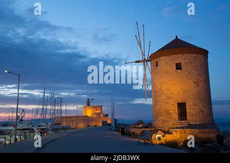 Evening in Rhodes Town with the Windmills of Mandraki along the jetty and the Fort of St Nicholas in the background, Mandraki Harbour, Rhodes Stock Photo