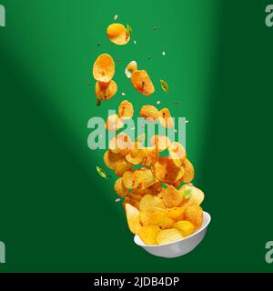 Potato chips falling onto plate on white background. Advertising concept. Levitation flying chips Stock Photo