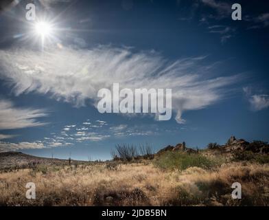 Feather cloud in the Arizona Sky. Cirrus clouds are sometimes referred to as 'feather clouds' or 'mares tails'. They're composed of hexagonal ice c... Stock Photo