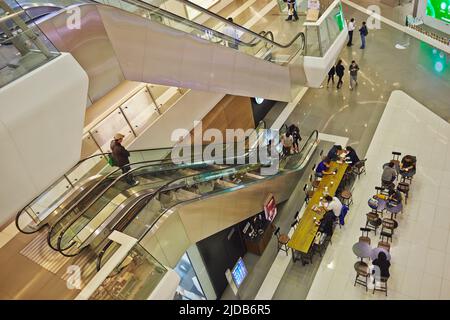 Interior of Hong Kong Plaza, with shoppers riding the escalators and eating in the concourse, near Xintiandi; Shanghai, China Stock Photo