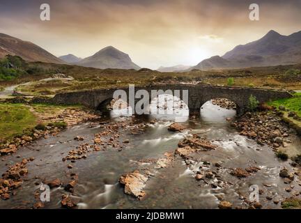 Sligachan old bridge on the Isle of Skye at beautiful sunset in Scotland. Nice landsape with river. Stock Photo