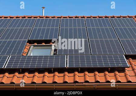 Solar panels installed on house roof, photovoltaic system converting energy from sunlight into clean, emission-free electricity to power a home all ye Stock Photo