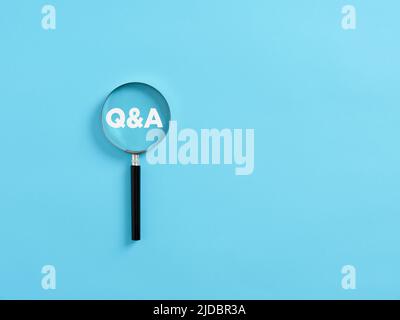 Magnifying glass on the acronym Q&A questions and answers. Business information faq concept. Stock Photo