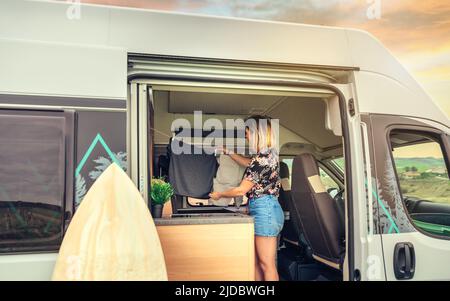 Woman hanging out the laundry inside her camper van Stock Photo