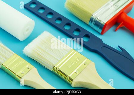 Various painting tools with brushes and rolls on blue background Stock Photo