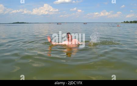 Hands of a drowning man above water in need of help. Stock Photo