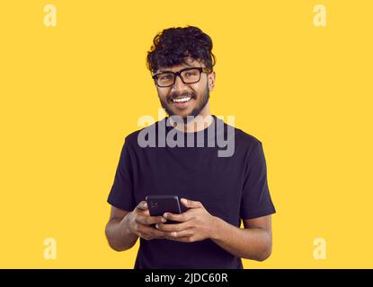 Smiling Indian man message online on cellphone Stock Photo