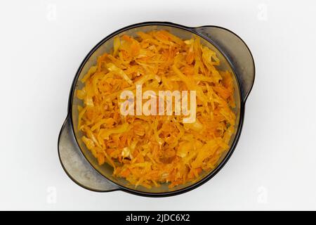 Cabbage stewed in tomato. Homemade steamed cabbage with fresh tomatoes and carrots in a black plate on a white background. Healthy, eco-friendly, Stock Photo