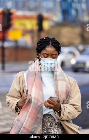 Woman wearing scarf on the move using cell phone Stock Photo