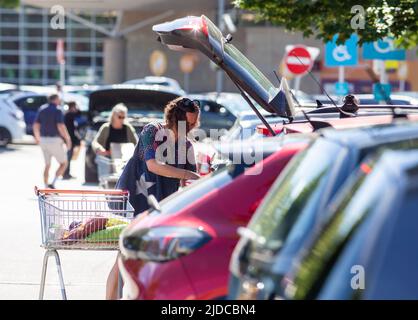Halifax West Yorkshire, UK. 20th June, 2022.   A female shopper unloads her trolley into her car at Sainsburys supermarket store in Halifax, West Yorkshire, UK, as the cost of the daily and weekly food shop rises sharply throughout the UK.   Credit: Windmill Images/Alamy Live News Stock Photo