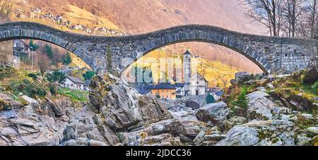 Historic Salt Bridge (Ponte degli Salti) across the rocky Verzasca River in front of Santa Maria degli Angeli Church, Lavertezzo, Valle Verzasca, Swit Stock Photo