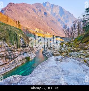 Walk down the rocky Verzasca River baseflow with a view on Ponte dei Salti (Salt Bridge) and Pizzo di Vogorno Mount in Lavertezzo, Valle Verzasca, Swi Stock Photo