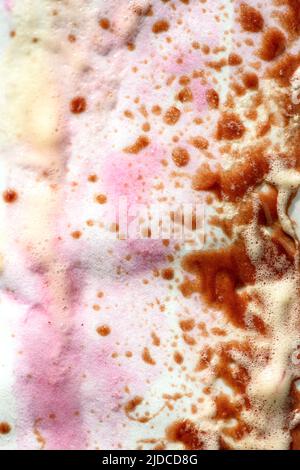 Abstract background of multicolored drops of melted ice cream on paper wrapping paper. Pink, yellow and brown messy spots Stock Photo